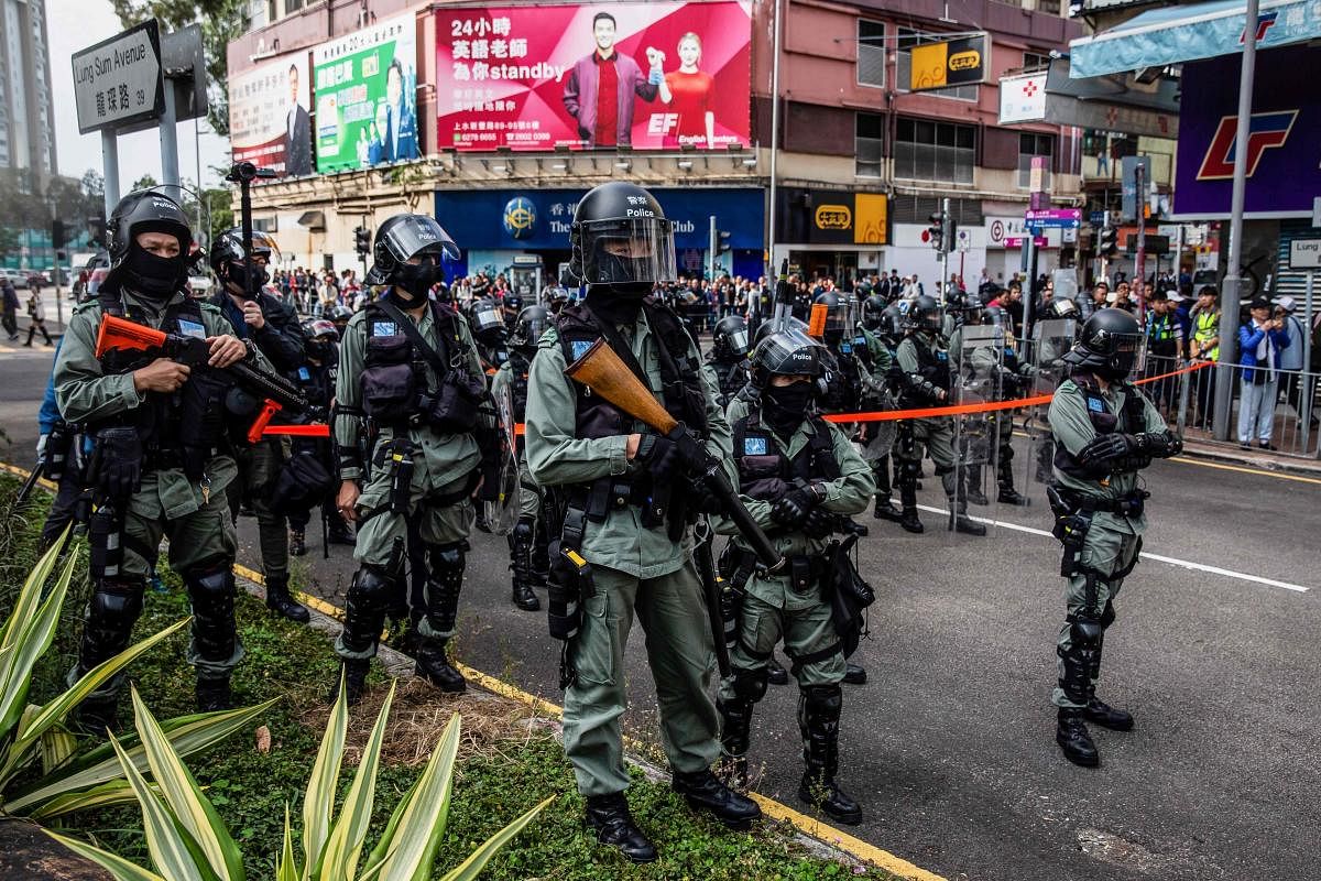 Riot police watch as pro-democracy protesters (not in picture) march along a street during a demonstration against parallel trading in Sheung Shui in Hong Kong on January 5, 2020. (AFP Photo)