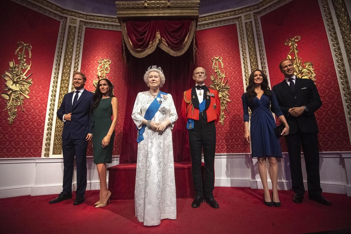 The figures of Britain's Prince Harry and Meghan, Duchess of Sussex, left, in their original positions next to Queen Elizabeth II, Prince Philip and Prince William and Kate, Duchess of Cambridge, at Madame Tussauds in London. (AP Photo)