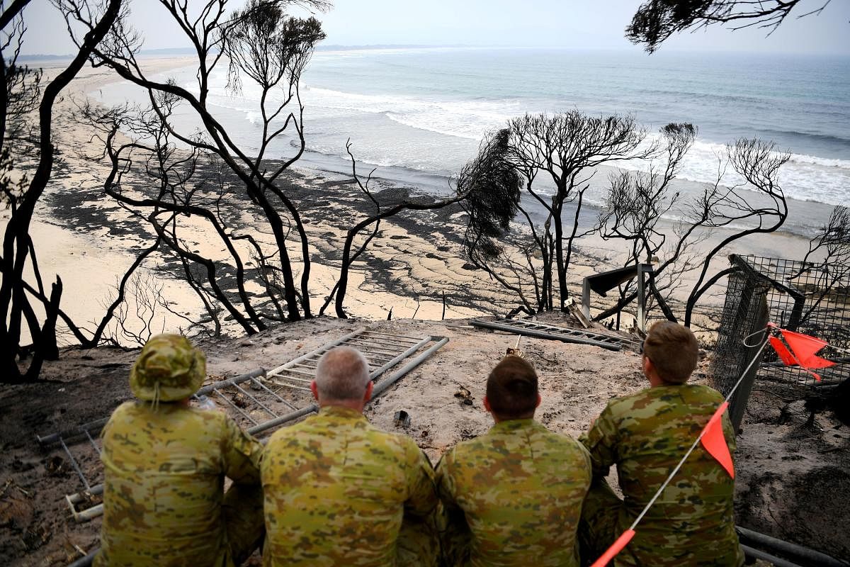 Soldiers sit on a beach amongst burnt trees where people had previously taken shelter during a fire on New Year's Eve in Mallacoota, Australia. (Reuters Photo)