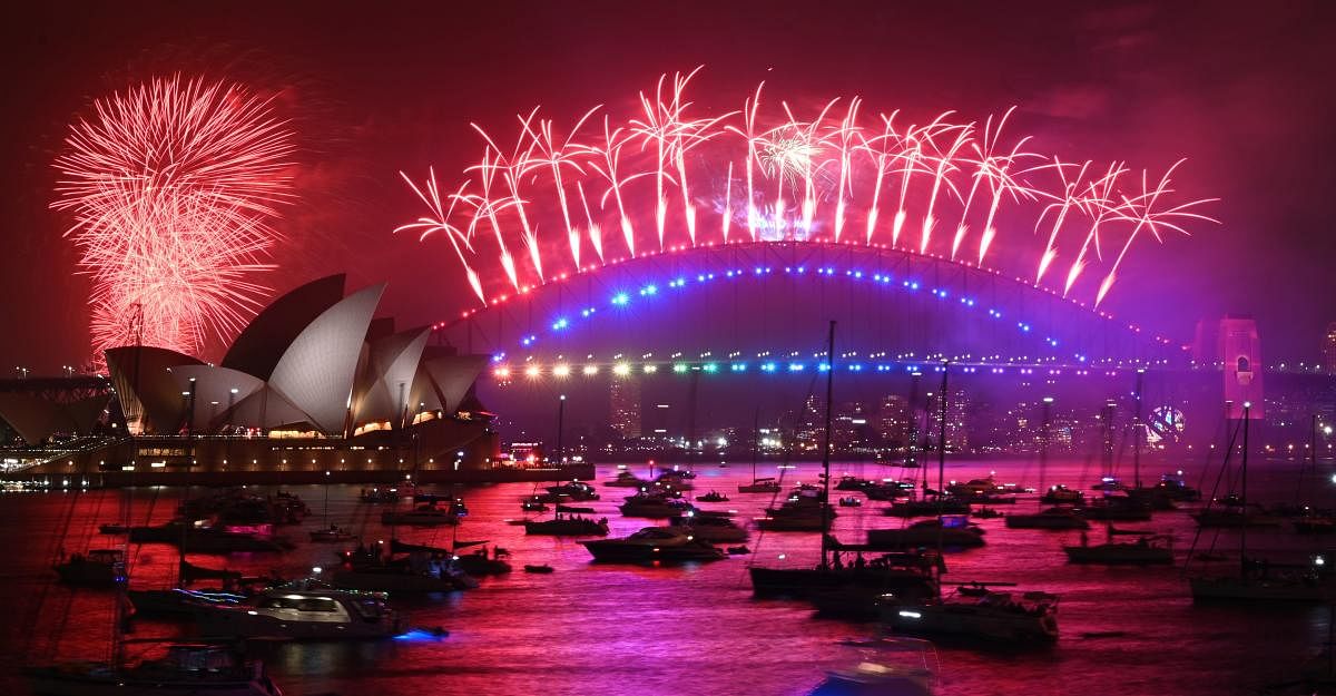 New Year's Eve fireworks erupt over Sydney's iconic Harbour Bridge and Opera House (L) during the fireworks show on January 1, 2020. AFP