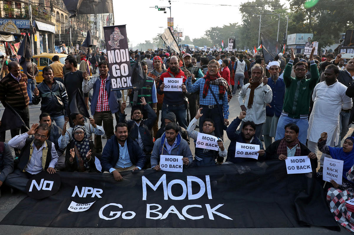 Demonstrators hold a banner and placards during a protest against the visit of India's Prime Minister Narendra Modi to the state and against a new citizenship law, in Kolkata. (Reuters photo)