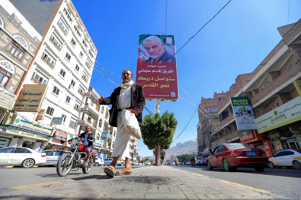 A Yemeni man walks beneath a poster of slain Iranian military commander Qasem Soleimani in the capital Sanaa, on January 8, 2020. (AFP Photo)