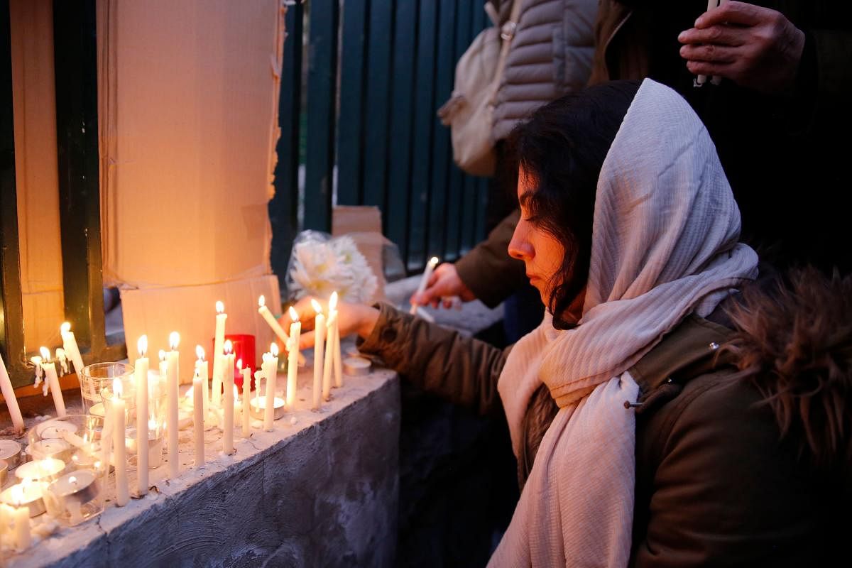 An Iranian lights candles for the victims of Ukraine International Airlines Boeing 737 during a gathering in front of the Amirkabir University in the capital Tehran. (AFP PHOTO)