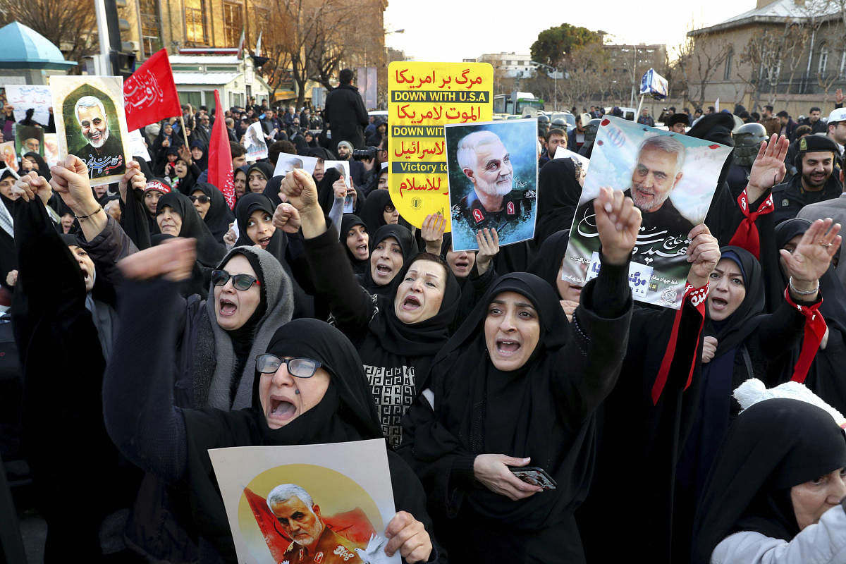 Protesters chant slogans while holding up posters of Gen. Qassem Soleimani during a demonstration in front of the British Embassy in Tehran, Iran, Sunday, Jan. 12, 2020. (AP Photo)