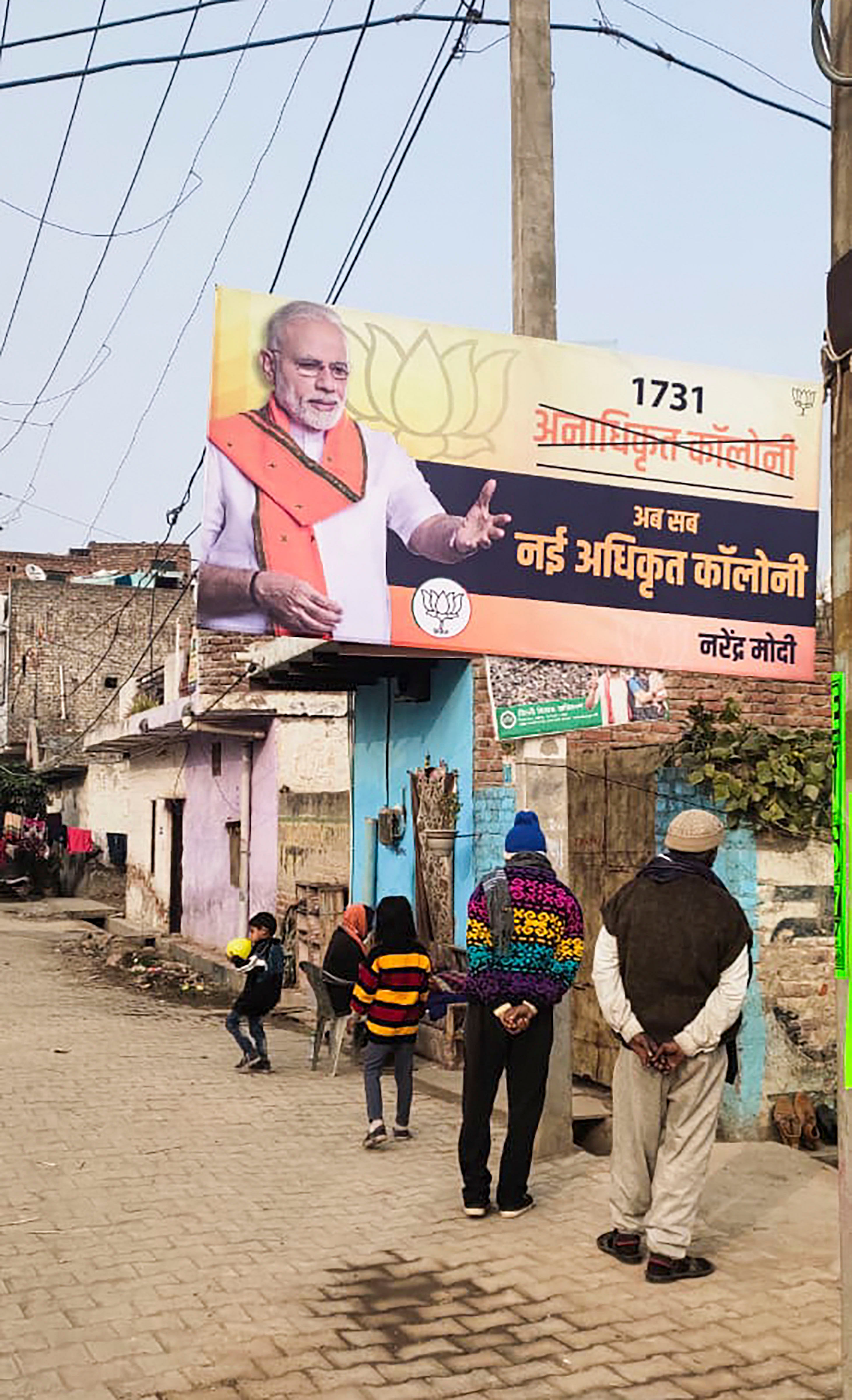 A poster of Narendra Modi on regularisation of unauthorised colonies is seen at a colony in New Delhi, Sunday, Dec. 29, 2019. The BJP have kick-started their campaign for the 2020 Delhi Assembly elections. (PTI Photo)