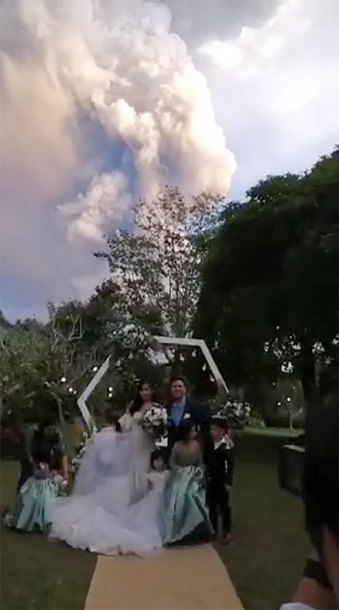 A couple poses during their wedding ceremony as Taal Volcano sends out a column of ash in the background, in Alfonso, Cavite, Philippines. (REUTERS photo)