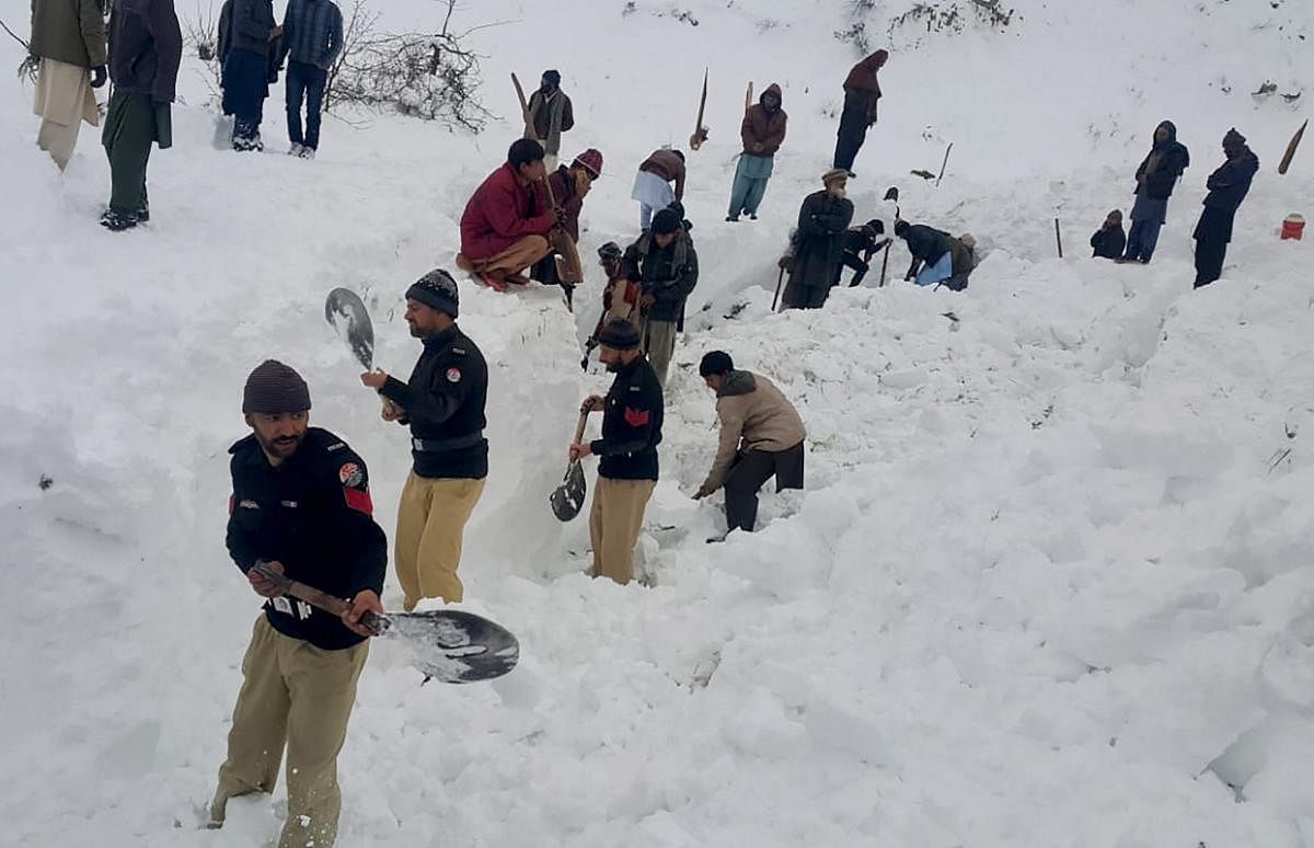 Police officers and local residents dig to search bodies of victims of avalanches in Doodnail village in Neelum Valley, Pakistan-administered Kashmir. (AP Photo)
