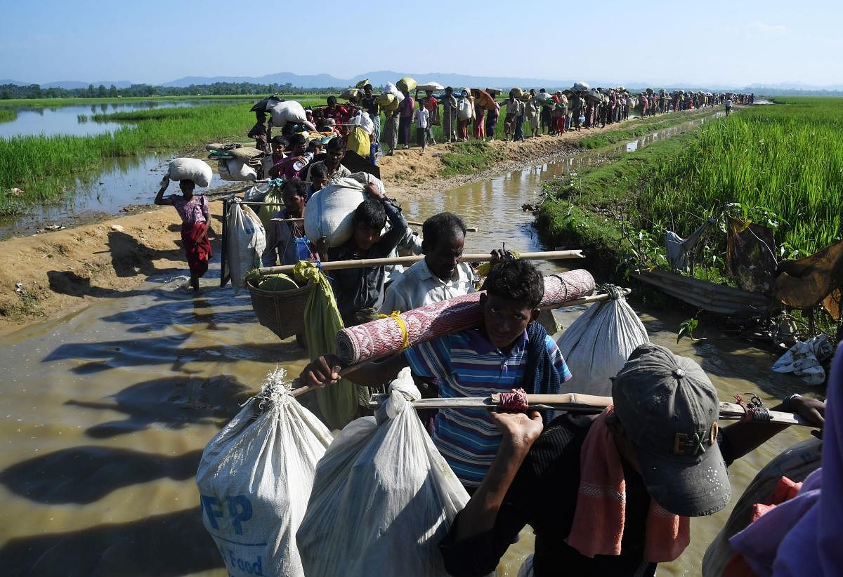 In this file photo taken on November 3, 2017, Rohingya Muslim refugees who were stranded after leaving Myanmar walk towards the Balukhali refugee camp after crossing the border in Bangladesh's Ukhia district. Credit: AFP File Photo
