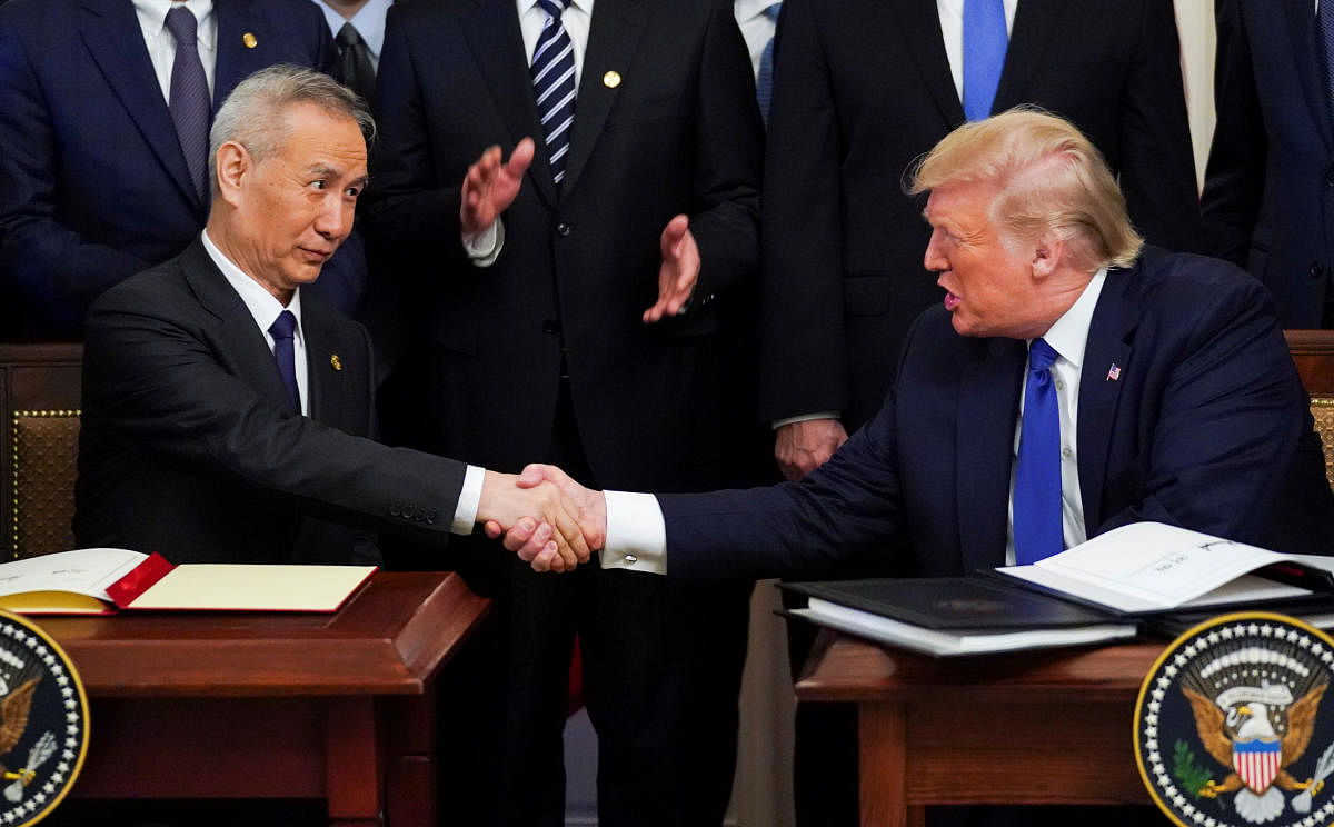 Chinese Vice Premier Liu He and U.S. President Donald Trump shake hands after signing "phase one" of the U.S.-China trade agreement during a ceremony in the East Room of the White House in Washington. (Reuters photo)