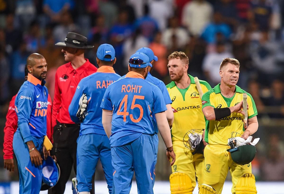 Australian batsman David Warner and Aaron Finch being congratulated by Indian players after they chased down the target to win the first one day international (ODI) cricket match at the Wankhede Stadium in Mumbai. (PTI PHOTO)