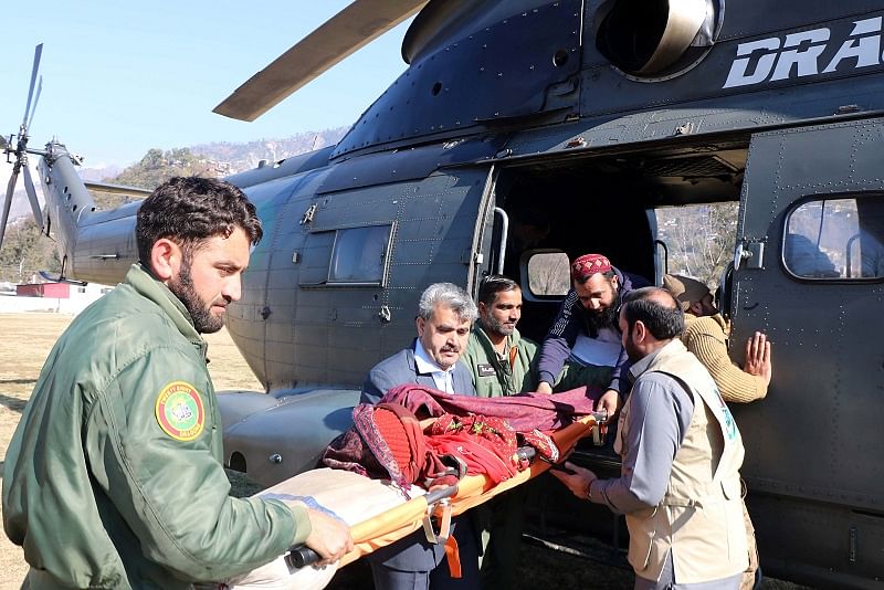 People transport an injured woman, who was rescued after heavy snowfall and avalanches in Neelum Valley near line of control (LoC), from a helicopter to a hospital in Muzaffarabad, Pakistan. (Reuters Photo)