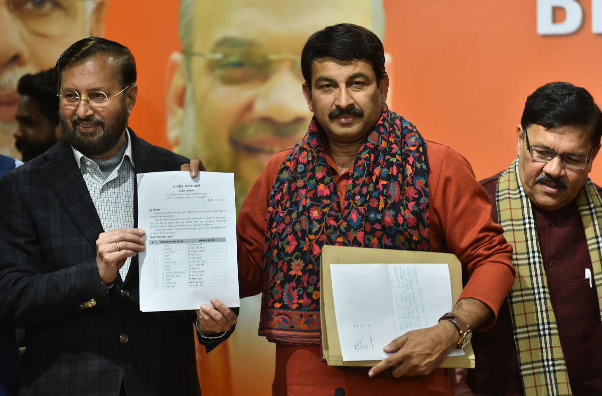 Delhi BJP State President Manoj Tiwari (C) with Union Minister Prakash Javadekar (L) and Bharatiya Janata Party (BJP) vice-president Shyam Jaju (R) during the release of BJP's first list of 57 candidates for Delhi Assembly polls. (PTI Photo)