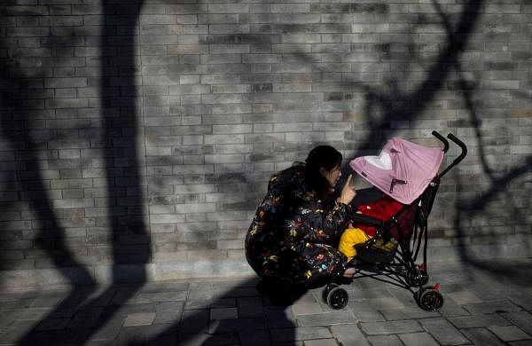 A woman talks to her baby in a stroller in Beijing on January 8, 2020. (AFP Photo)