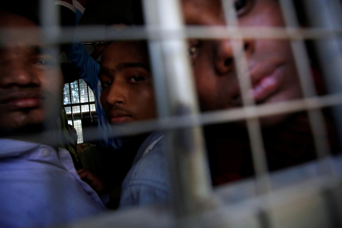 Rohingya Muslim men look out from inside a police vehicle, as they are transported from a court hearing on charges of illegally travelling without proper documents, in Pathein. (REUTERS photo)