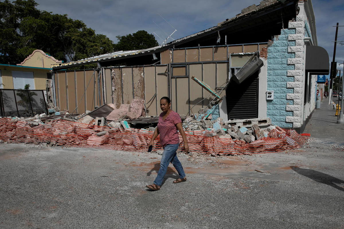 A woman walks past a damaged store after an earthquake in Guanica, Puerto Rico. (Reuters Photo)