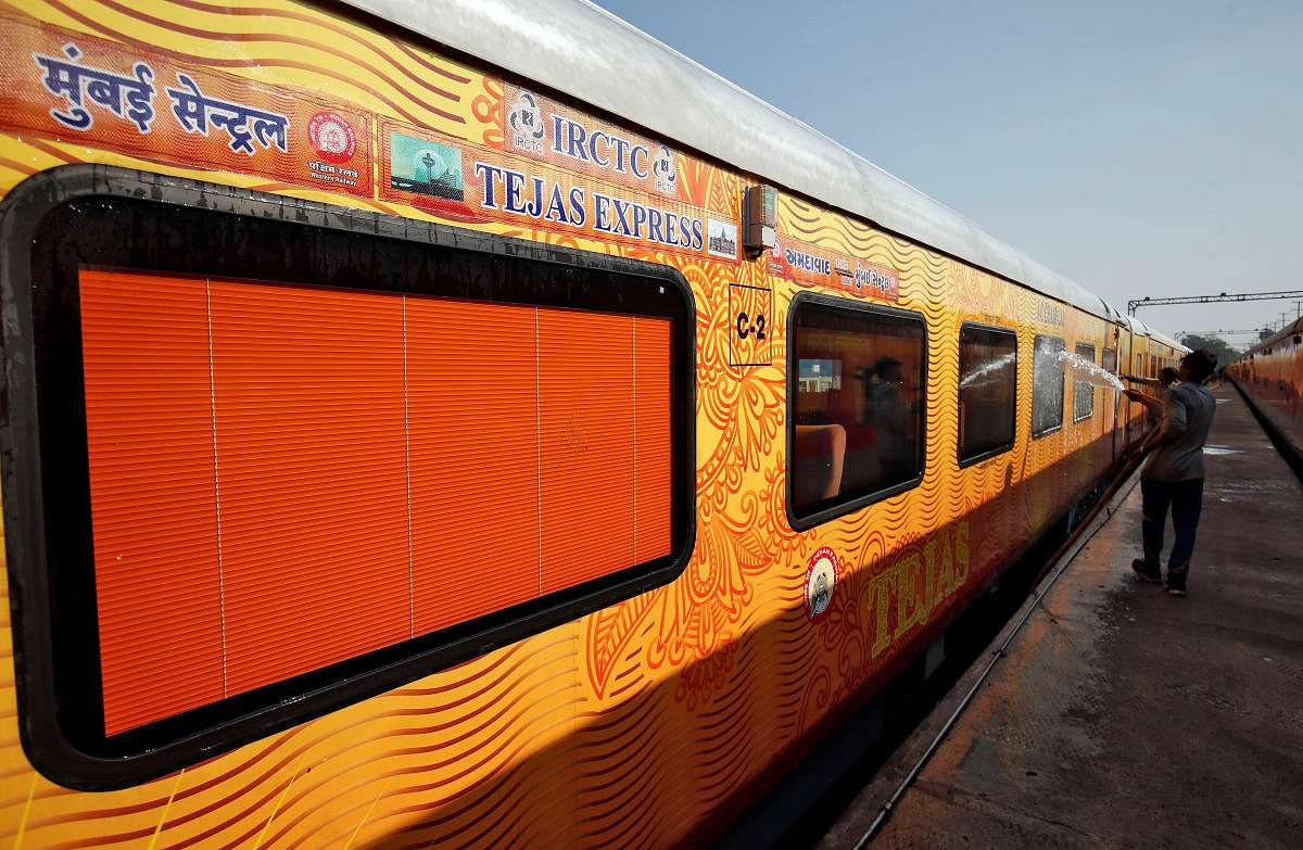 A man cleans the exteriors of a coach of India's first private train Tejas Express during a media tour at a railway yard in Ahmedabad. (REUTERS photo)