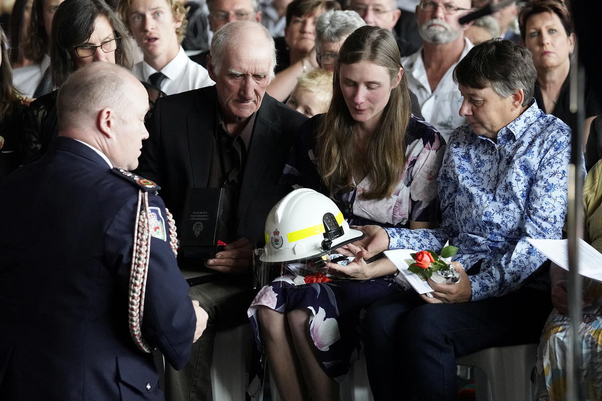 NSW Fire Commissioner Shane Fitzsimmons presents the helmet of NSW Rural Fire Service (RFS) volunteer firefighter Samuel McPaul to his widow, Megan (Reuters Photo)