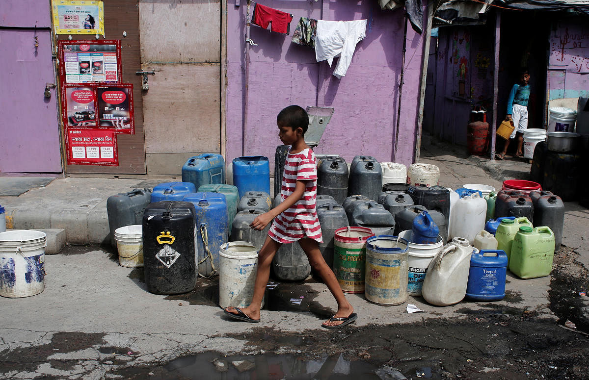 A girl walks past the empty water containers kept by the residents to collect free drinking water from a municipal tanker in New Delhi, India, June 28, 2019. (Reuters Photo)