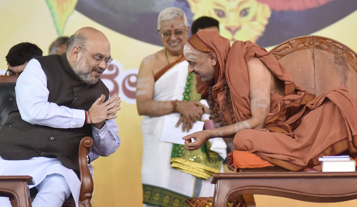 Union Minister of Home Affairs Amit Shah greets Yadathore Sri Yoganandeshwara Saraswati Mutt seer Shankara Bharati Swami during ‘Vivekadeepini Mahasamarpane’ programme at the Palace Grounds in Bengaluru on Saturday. DH Photo/Janardhan B K