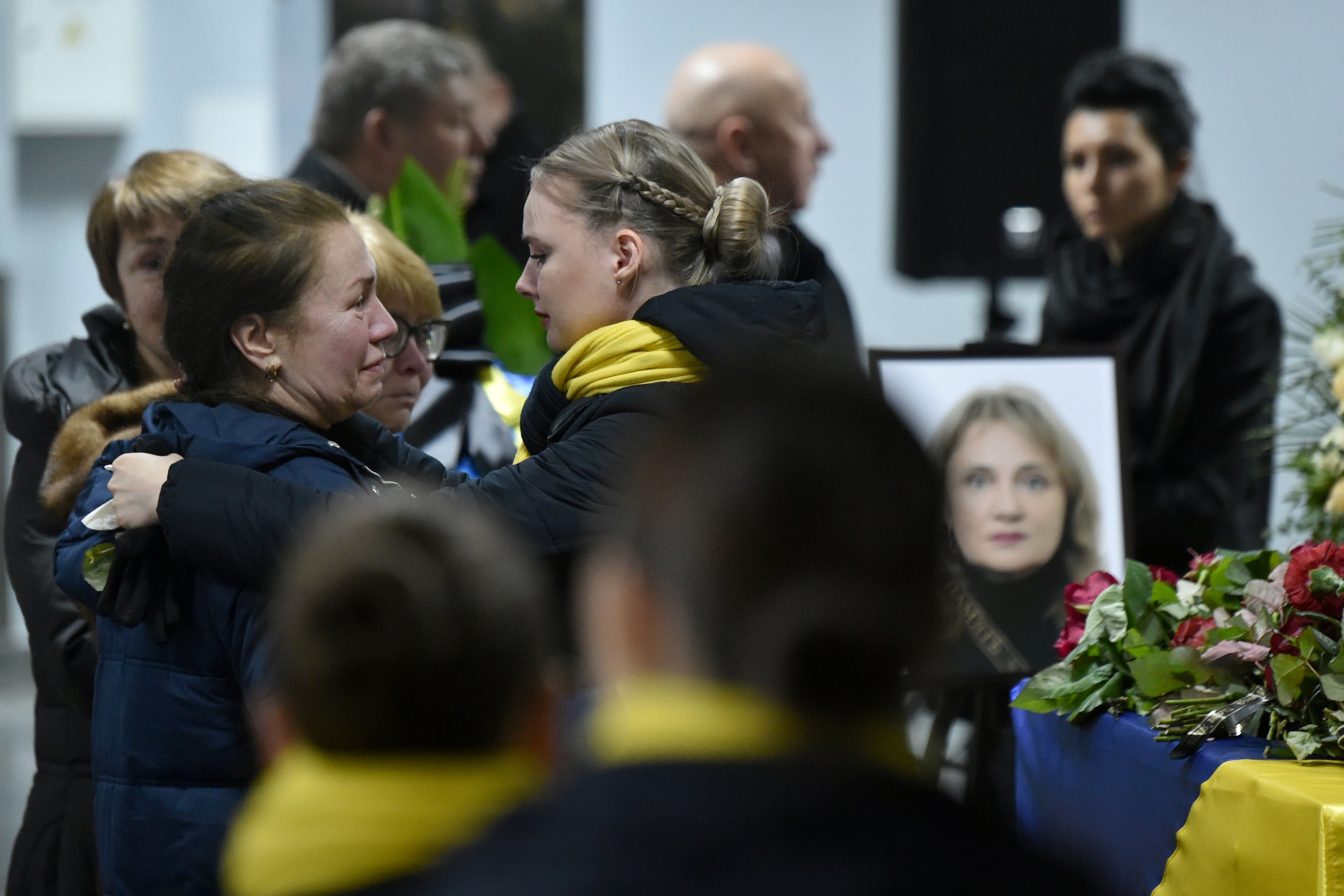 Relatives and colleagues attend a tribute ceremony and react in front of the flag-draped coffins of the 11 Ukrainians who died in a plane mistakenly shot down by Iran during a spike in tensions with Washington, which arrived in Boryapil airport, outside Kiev. (AFP Photo)