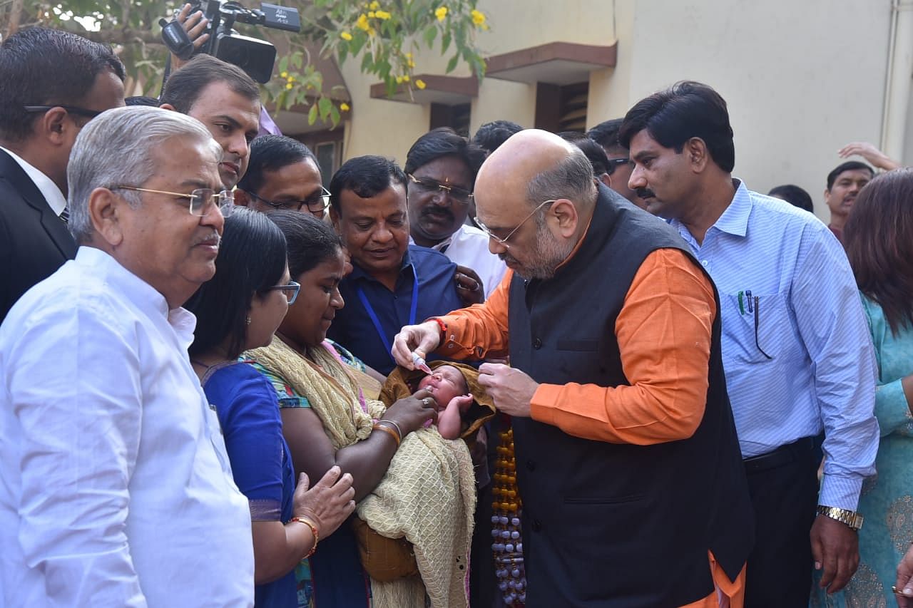 Union Home Minister Amit Shah administering polio drops to a child at Union parliamentary affairs minister Pralhad Joshi's House in Hubballi on Sunday. (DH Photo)