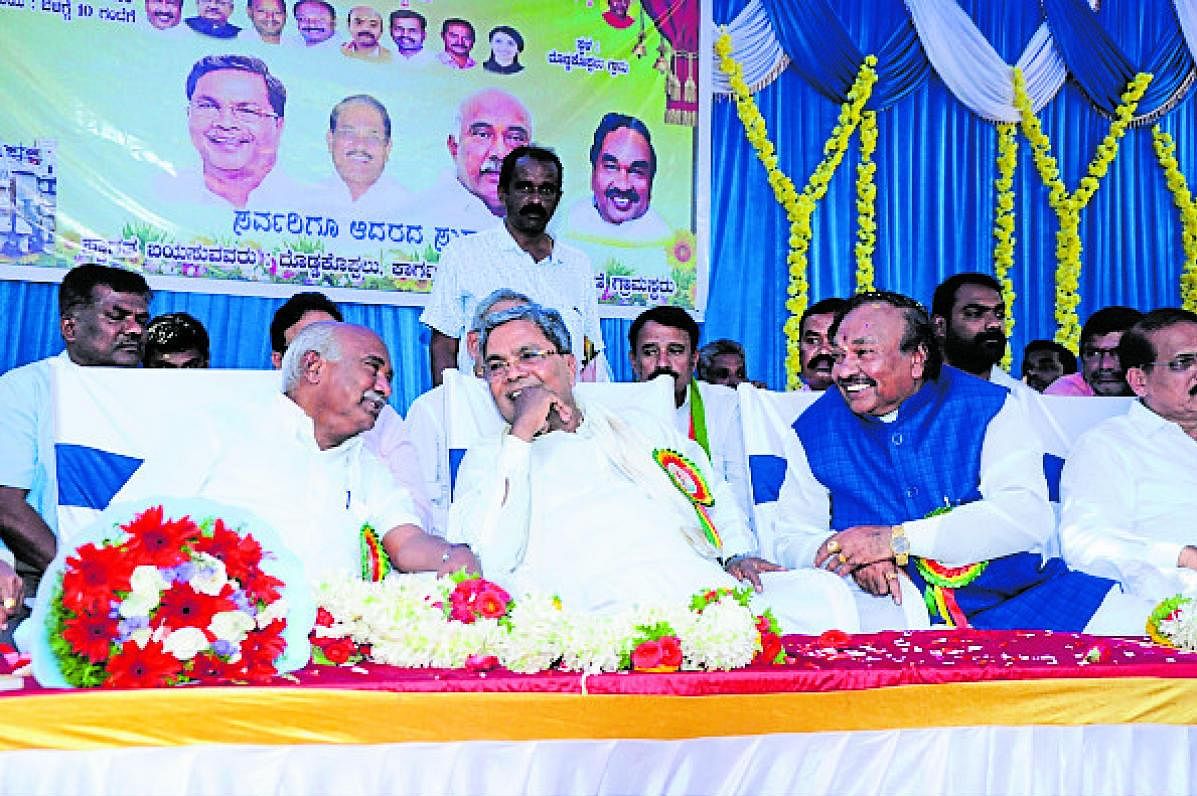 Leader of the Opposition in the Assembly Siddaramaiah, BJP leader A H Vishwanath and Minister K S Eshwarappa at a programme in Doddakoppalu village, K R Nagar taluk of Mysuru district on Sunday. (DH Photo)