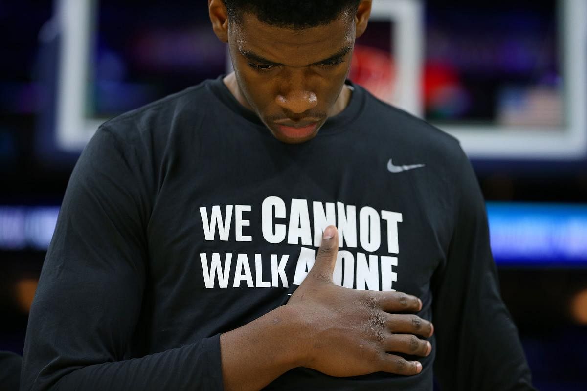 Brandon Slater #3 of the Villanova Wildcats places his hand over his chest during the playing of the national anthem before a college basketball game against the Connecticut Huskies at Wells Fargo Center on January 18, 2020 in Philadelphia, Pennsylvania.  (Photo by AFP)