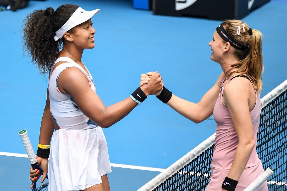 Japan's Naomi Osaka (L) shakes hands with Czech Republic's Marie Bouzkova after victory during their women's singles match on day one of the Australian Open. (AFP Photo)