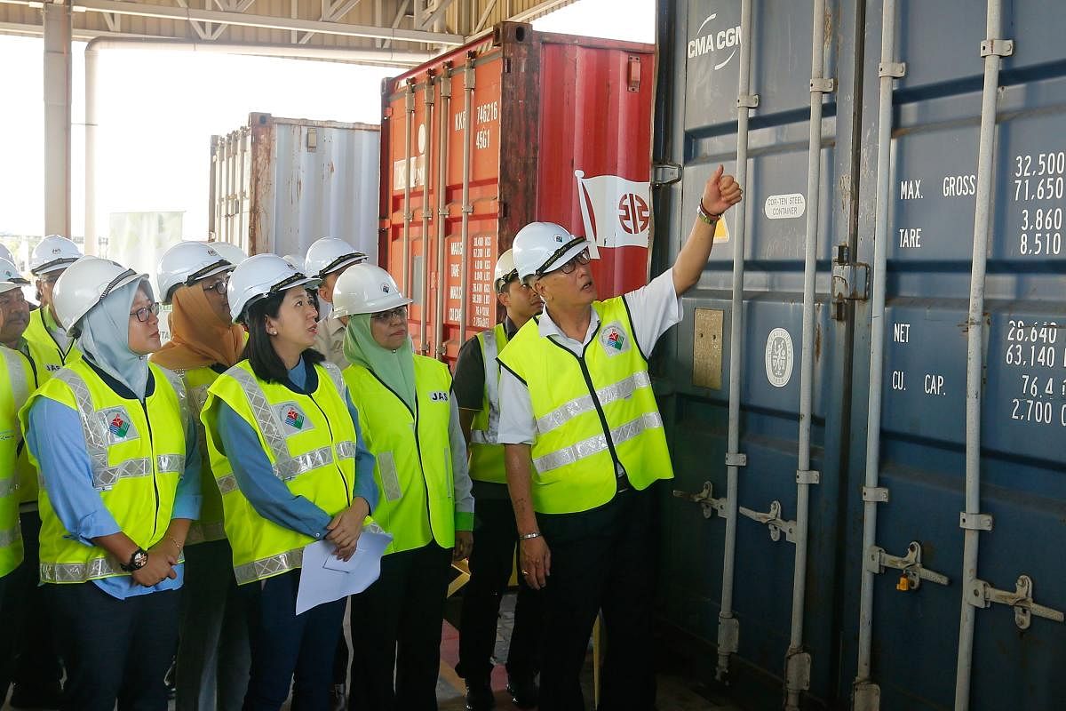 Malaysian Environment Minister Yeo Bee Yin (front 2nd L) and officials inspect a container containing plastic waste shipment before sending back to the countries of origin. (AFP Photo)