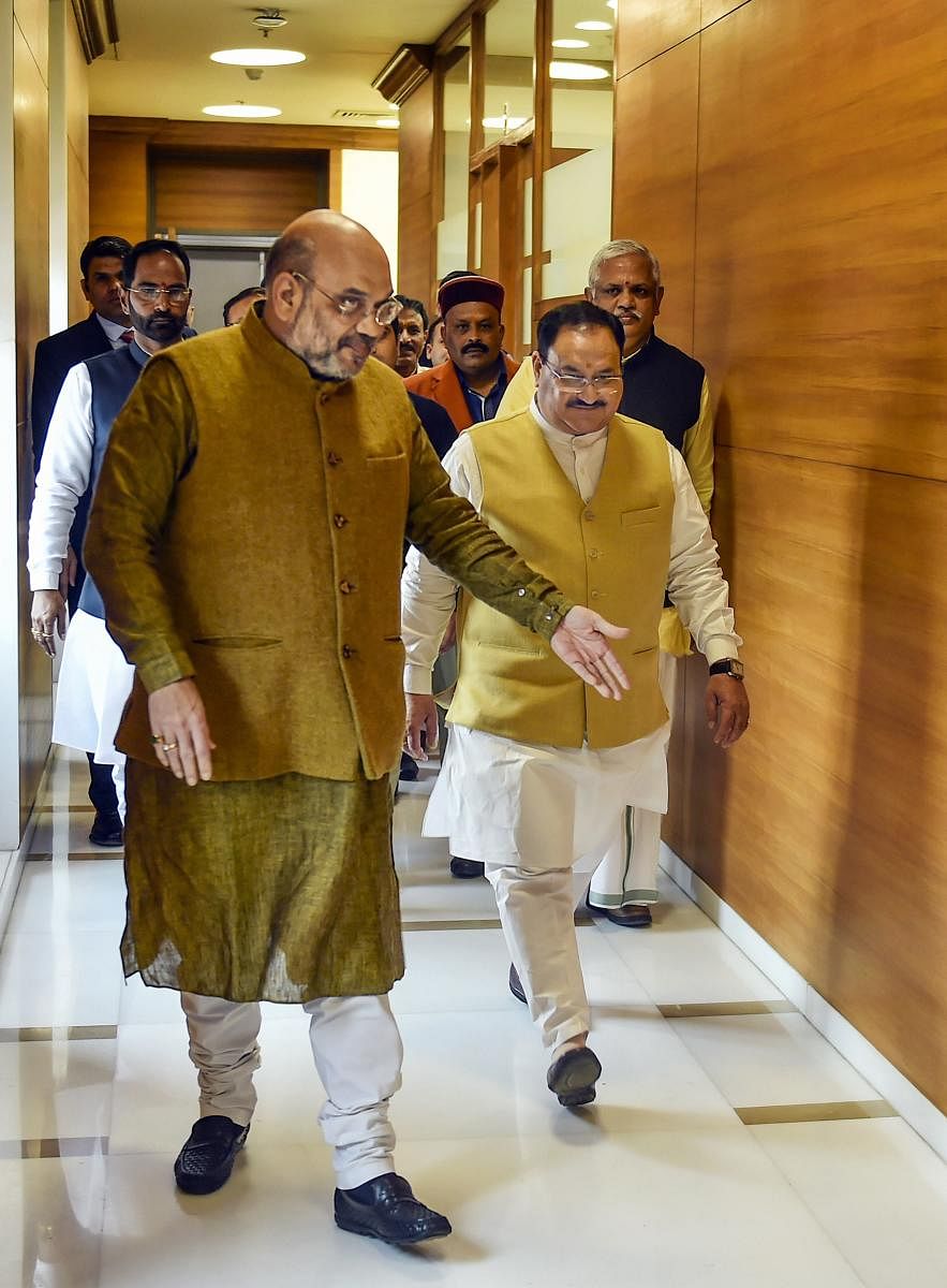 Union Home Minister and outgoing BJP President Amit Shah (L) with his successor J P Nadda at the party headquarters, in New Delhi. (PTI PHOTO)