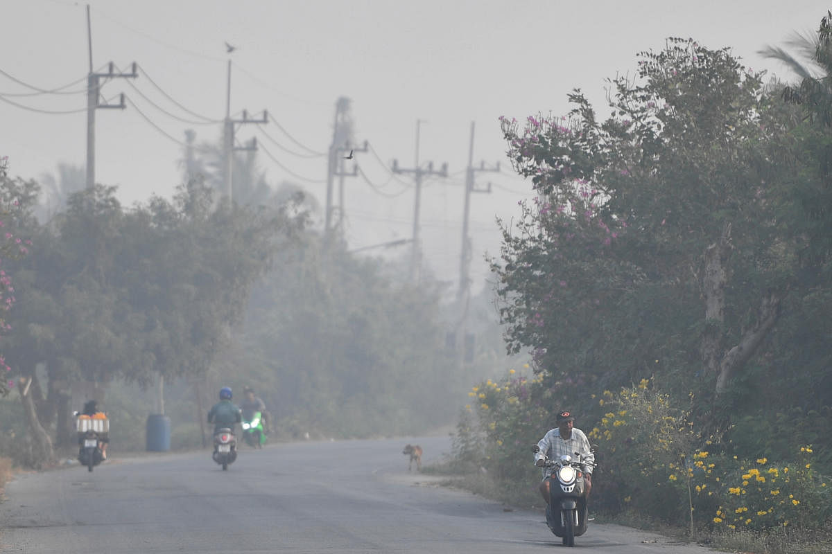 A road is seen with smog next to a sugar cane burnt plantations in Suphan Buri province, north of Bangkok, Thailand. Reuters