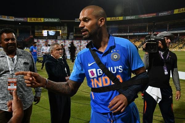 Shikhar Dhawan, wearing a arm sling post his onfield injury, speaks with a match official after India won the third and last one day international (ODI) cricket match of a three-match series between India and Australia at the M. Chinnaswamy Stadium in Bangalore on January 19, 2020. (AFP Photo)