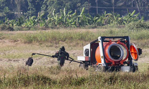 A bomb disposal squad member carries the suspicious bag, allegedly containing an IED component, for defusal, after it was found at the airport in Mangaluru, Monday, Jan. 20, 2020. Officials of Central Industrial Security Force (CISF) confirmed that low intensity IED was found in the bag. (PTI Photo)