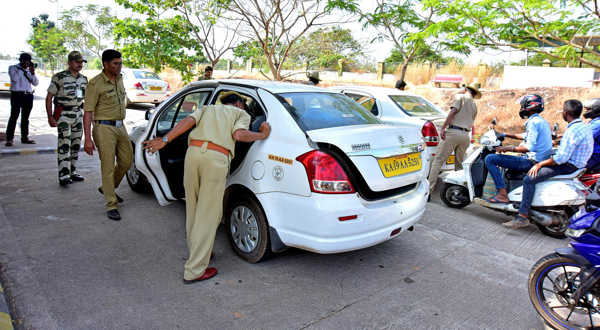 Police and CISF staff members check a vehicle entering the Mangalore International Airport at the manned entry gate.