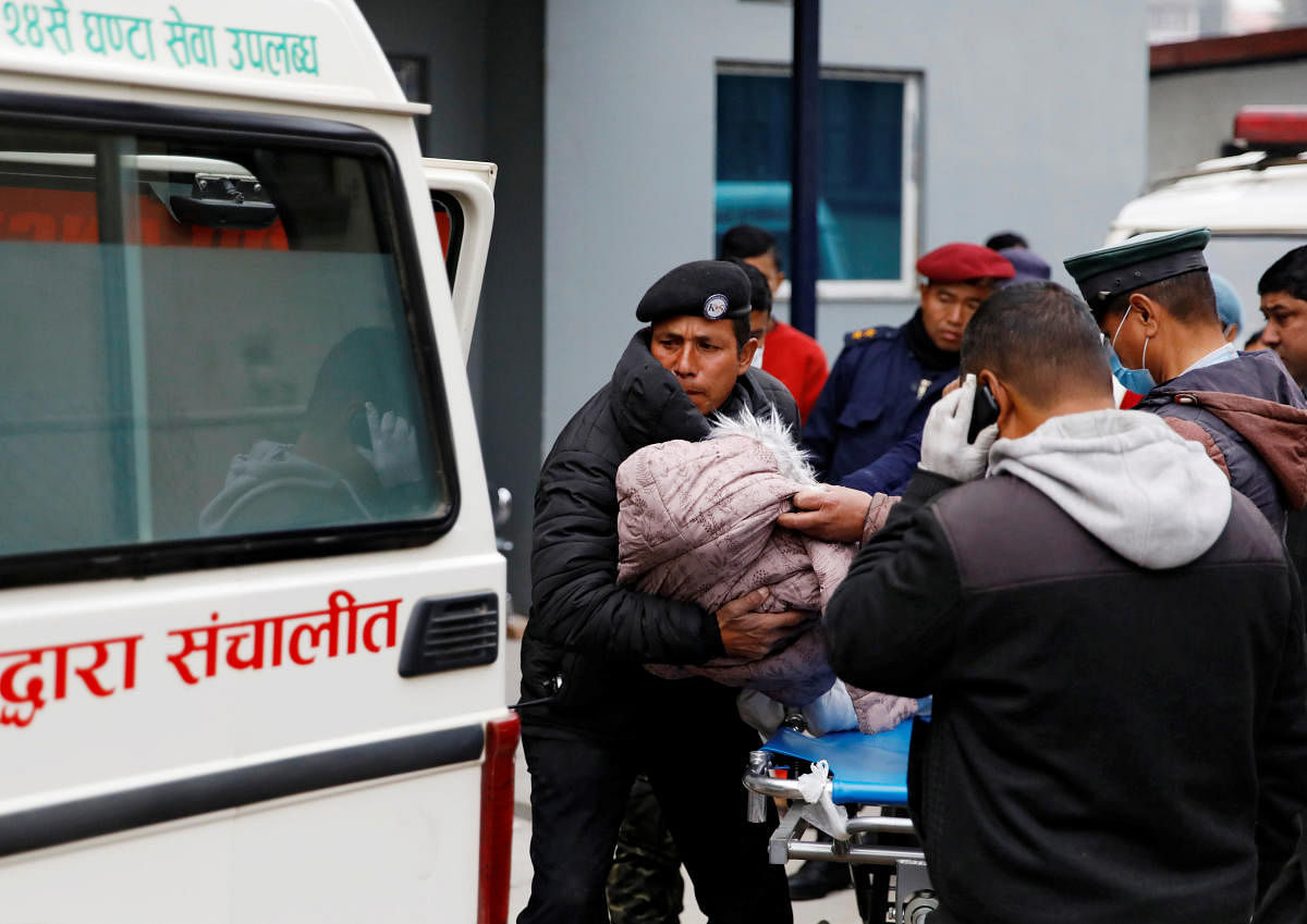 A body of a child who is among the eight Indian tourists who died due to suspected suffocation is being carried inside an ambulance while being taken for postmortem in Kathmandu. Credit: Reuters