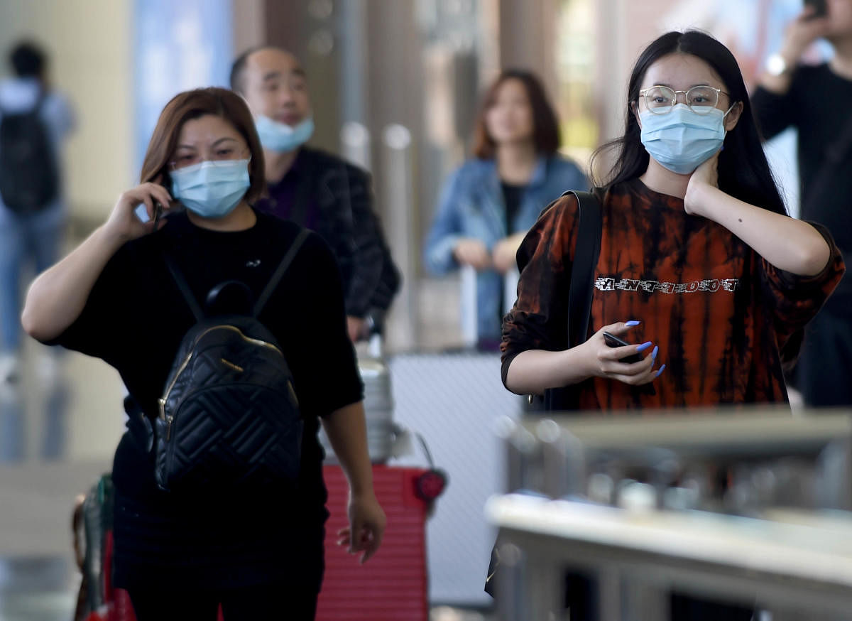 Chinese tourists wearing masks arrive at Ngurah Rai international airport in Denpasar, on Indonesia's resort island of Bali on January 23, 2020. (AFP Photo)
