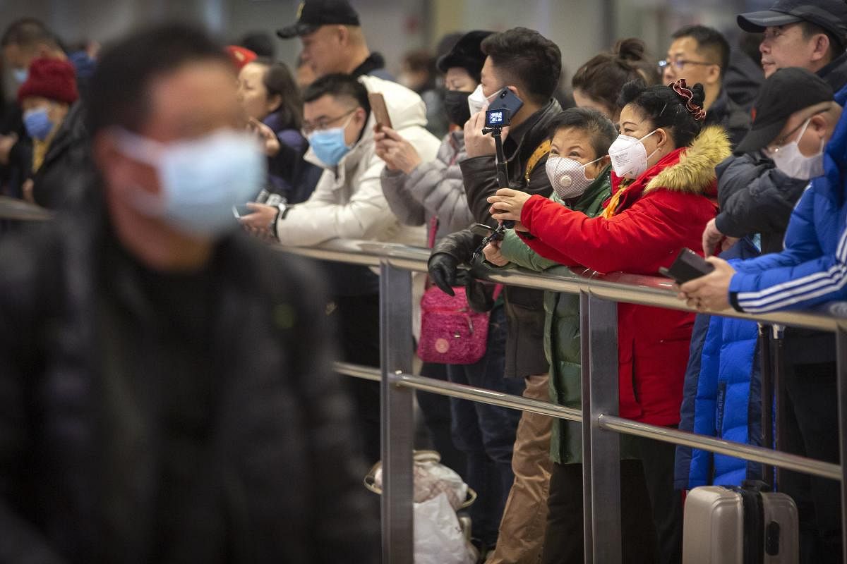 People wear face masks as they wait for arriving passengers at Beijing Capital International Airport in Beijing, Thursday, Jan. 23, 2020. (PTI Photo)