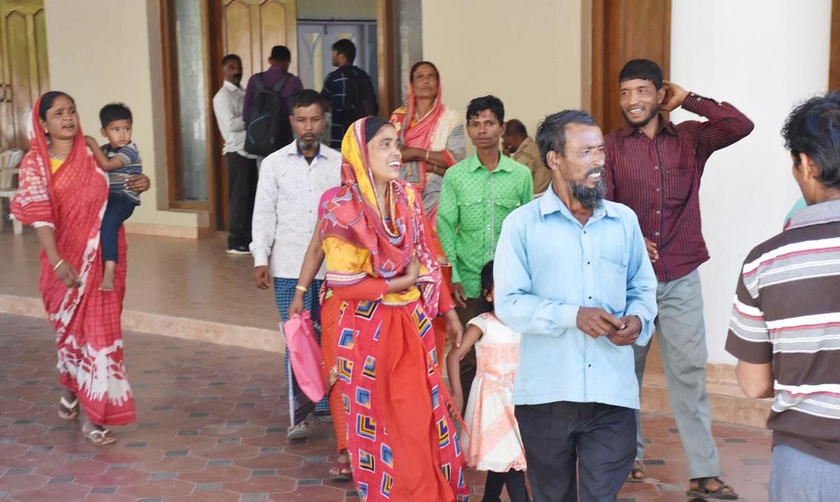 Migrant labourers come out of Crystal Hall after police verification of their identity documents, in Madikeri on Thursday. DH Photo