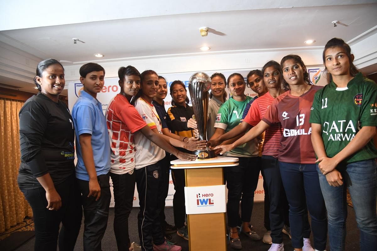 Captains of all twelve teams of the Indian Women’s League pose with the Indian Women’s League trophy in Bengaluru on Thursday. Photo/ B H Shivakumar