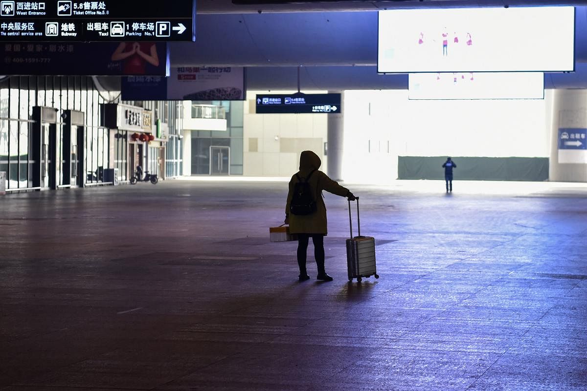 A passenger stands after arriving at the nearly-deserted Wuhan train station, usually full of passengers ahead of the Lunar New Year, in Wuhan on January 23, 2020, described as the "main battlefield" for a SARS-like disease has killed at least 17 people and left more than 500 sick so far. AFP