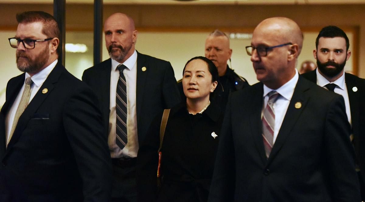Huawei chief financial officer Meng Wanzhou, after a short morning session that ended the fourth day of trial in her extradition case, leaves British Columbia Supreme Court with her security detail on January 23, 2020 in Vancouver, British Columbia. (AFP