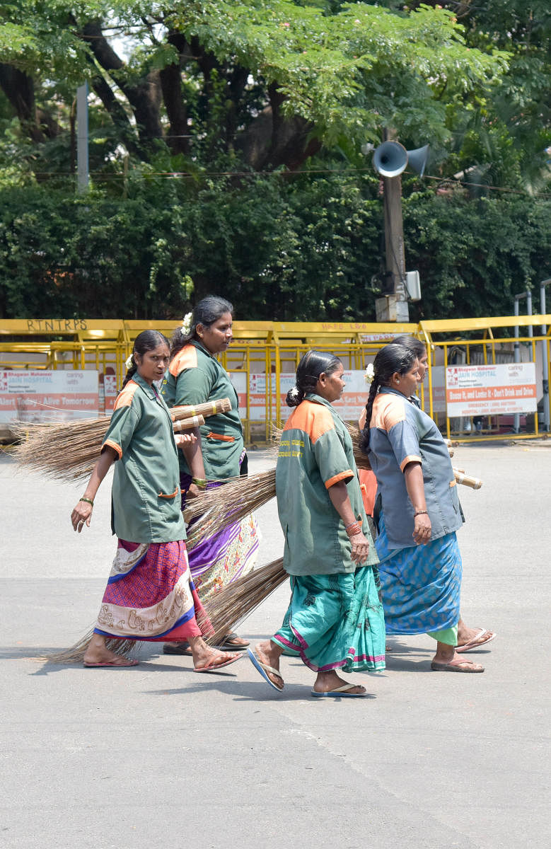 BBMP pourakarmikas are seen out side the Mount Carmel College counting centre, in Bengaluru on Thursday. (Photo/ B H Shivakumar)