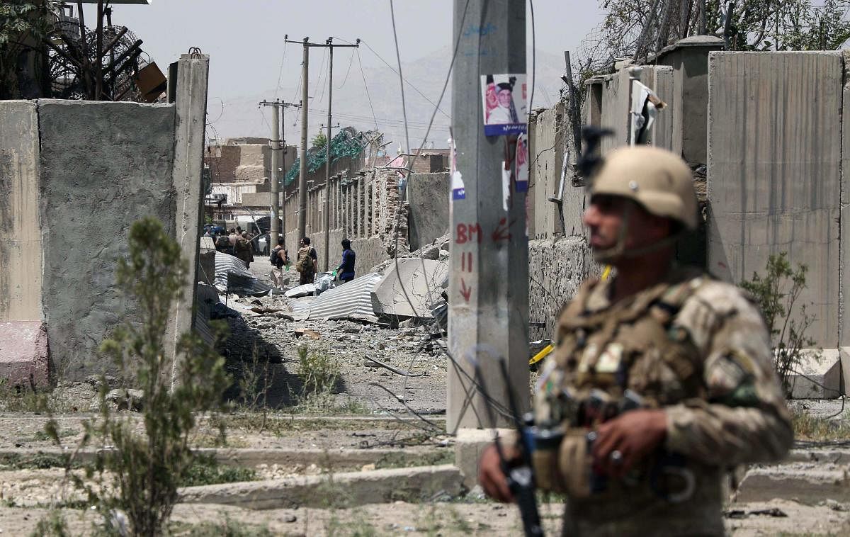 An Afghan security personnel stands guard at the site where a Taliban car bomb detonated at the entrance of a police station in Kabul on August 7, 2019. (AFP Photo)