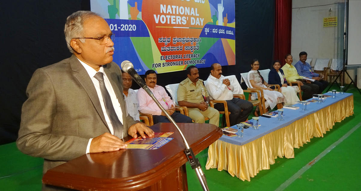 Principal District and Sessions Judge C M Joshi addresses the gathering after inaugurating the National Voters’ Day programme at the Town Hall in Ajjarkad in Udupi on Saturday.