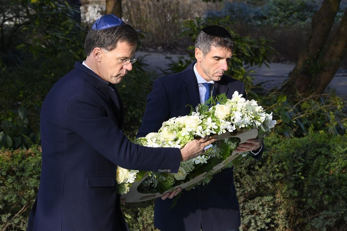 Prime Minister Mark Rutte (L) and State Secretary Paul Blokhuis (Health, Welfare and Sport) lay a wreath at the Auschwitz Never Again monument during during the National Holocaust Remembrance Day in Amsterdam, on 26 January 2020. (Photo by AFP) 