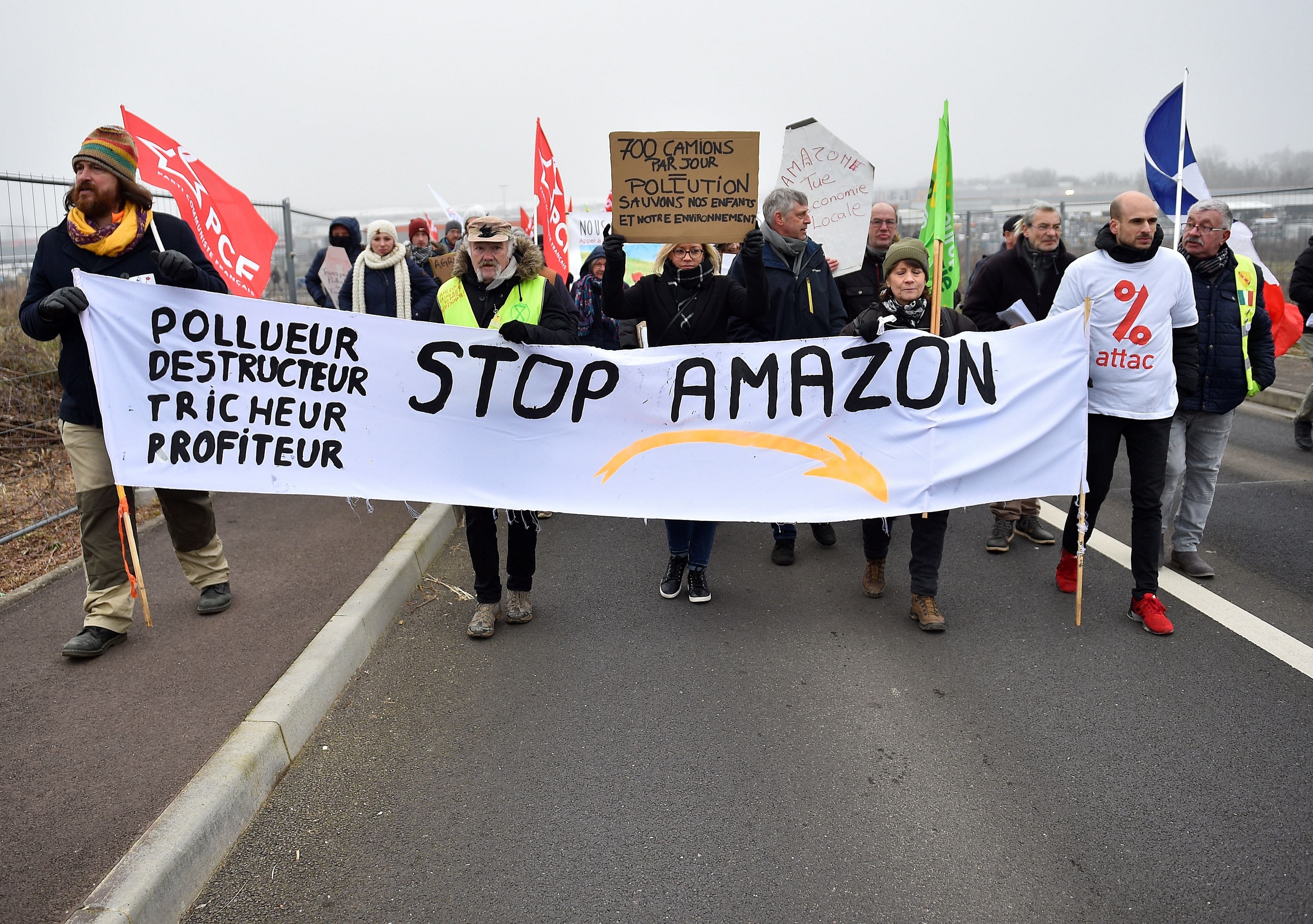 Protesters hold banners and placards during a demonstration against the installation of a warehouse of the online retailer Amazon on the former military air base of Frescaty. (AFP Photo)