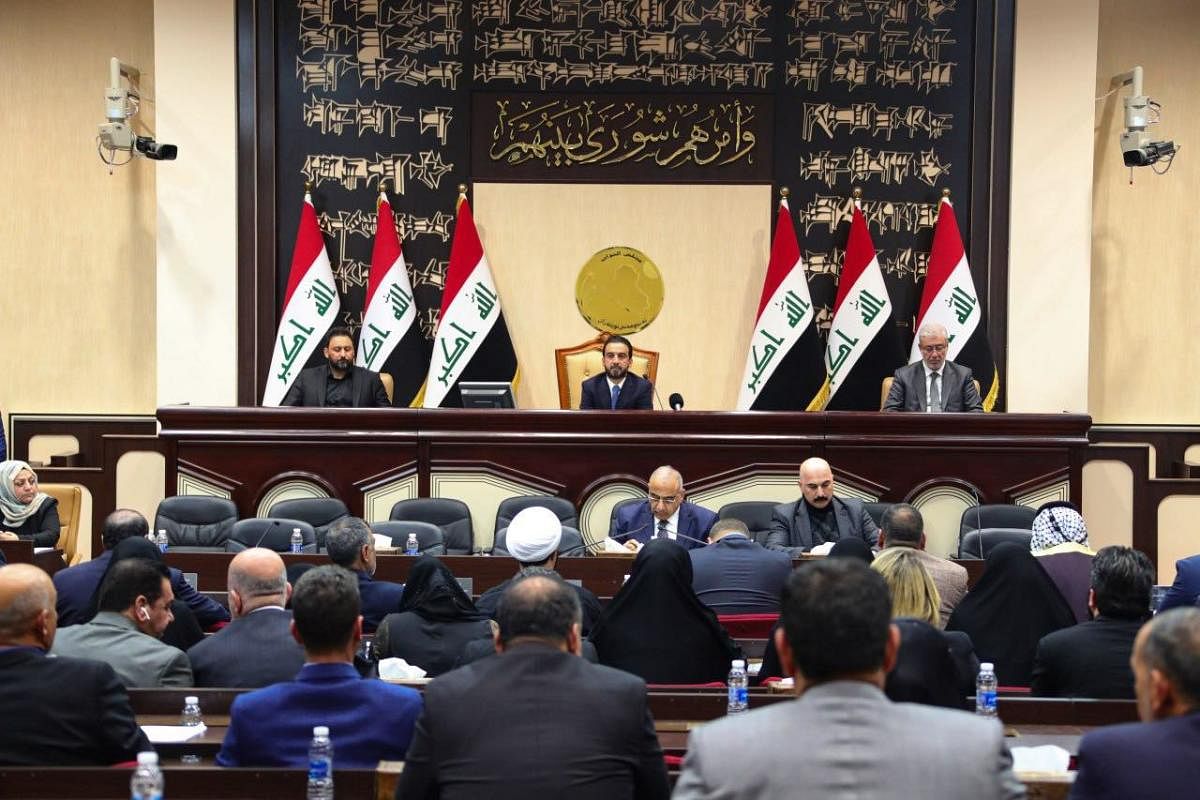 A handout picture released by Iraqi Prime Minister's Media Office on January 5, 2020 shows Iraq's caretaker prime minister Adel Abdul Mahdi (C-down) and Parliament Speaker Mohammed Halbusi (C-up) attending a parliamentary session regarding the ouster of U