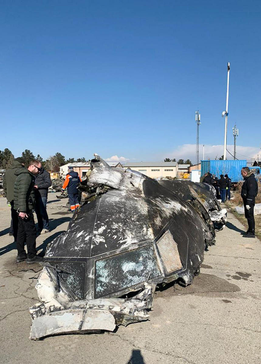 People standing and analysing the fragments and remains of the Ukraine International Airlines plane Boeing 737-800 that crashed outside the Iranian capital Tehran on January 8, 2020. (Credit: AFP Photo)