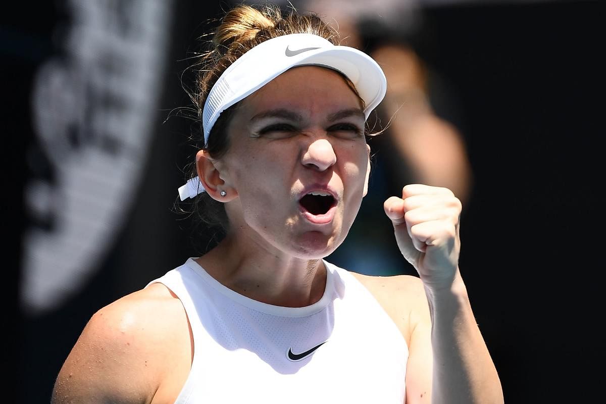 Romania's Simona Halep celebrates after beating Belgium's Elise Mertens during their women's singles match on day eight of the Australian Open tennis tournament in Melbourne on January 27, 2020. (AFP Photo)