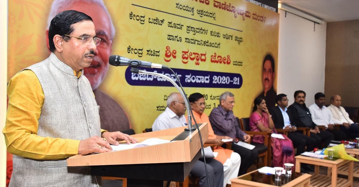 Union minister Pralhad Joshi speaks at the pre-budget interaction programme held at the KCCI hall at J C Nagar in Hubballi on Monday. (PTI Photo)